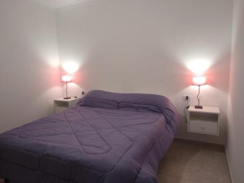 a bedroom with a bed and two lamps on two tables at Los Olivos Apart in San Rafael
