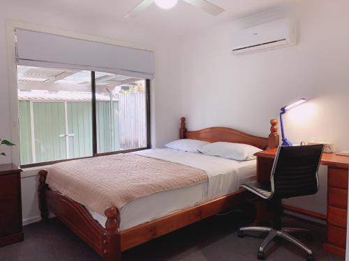 1 dormitorio con cama, escritorio y silla en Home Away From Home-(Room1&2) en Gold Coast