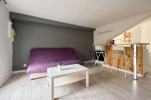 un salon avec un canapé violet et une table dans l'établissement Le Transvaal : À deux pas du centre., à Dijon