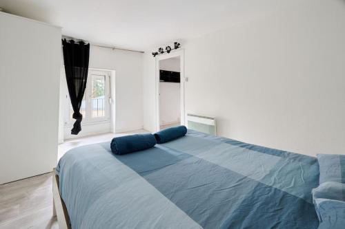 - une chambre avec un lit doté de draps bleus et une fenêtre dans l'établissement Le Transvaal : À deux pas du centre., à Dijon