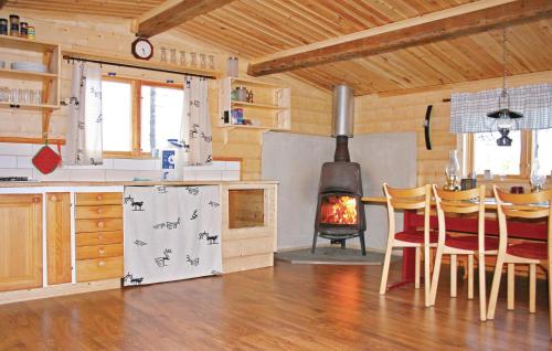 a kitchen with a stove and a table and chairs at Amazing Home In Arvidsjaur With Sauna in Lomträsk