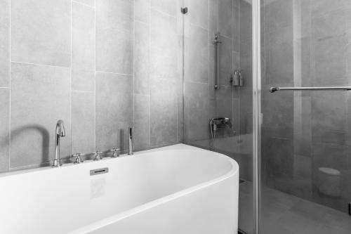 a bathroom with a white tub and a shower at Kenting Sea Wall 112 in Kenting