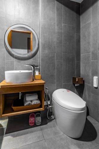 a bathroom with a white toilet and a mirror at Kenting Sea Wall 112 in Kenting