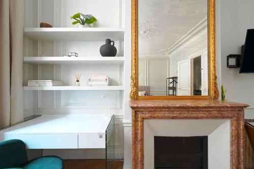 um espelho numa sala de estar com lareira em Studio Quartier Champs Elysées 1 em Paris