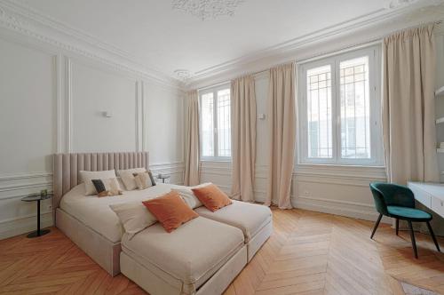 1 dormitorio con 1 cama blanca grande con almohadas de color naranja en Studio Quartier Champs Elysées 1, en París