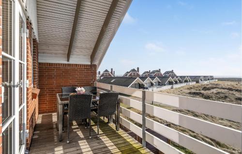 a balcony with a table and chairs and the ocean at 3 Bedroom Amazing Home In Rm in Havneby