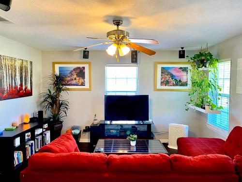 een woonkamer met een rode bank en een flatscreen-tv bij My Castle in San Marcos in San Marcos