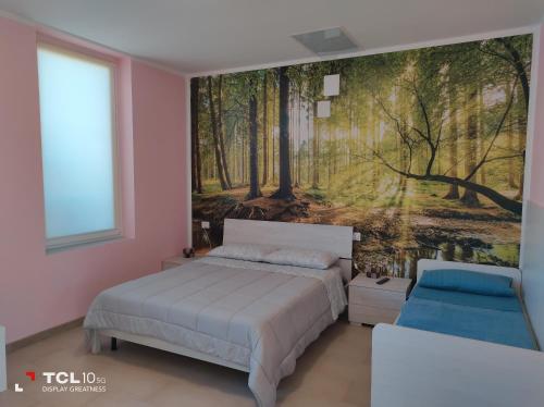 1 dormitorio con 1 cama y una pintura de un bosque en Villa ARA rossa, en Canegrate