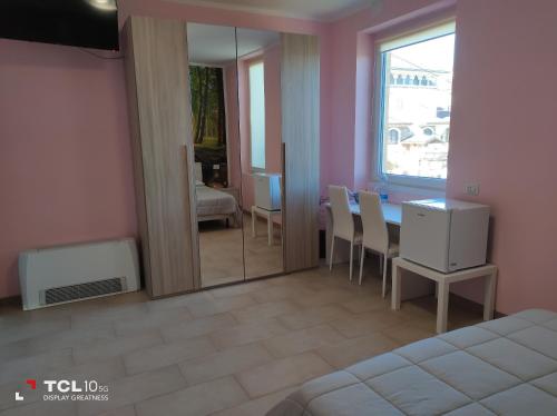 um quarto com uma mesa, cadeiras e um espelho em Villa ARA rossa em Canegrate