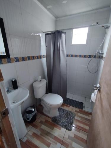 a bathroom with a toilet and a shower and a sink at Casa playa Pullay in Pullay