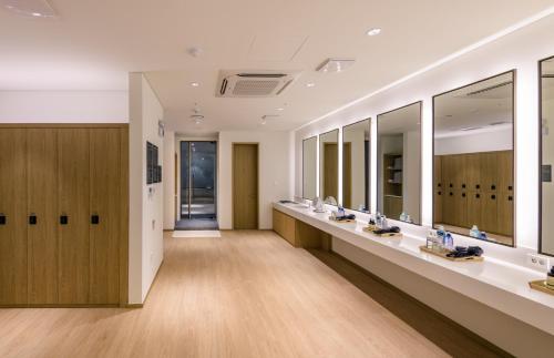 a dressing room with mirrors and a row of sinks at The Grand Sumorum in Seogwipo