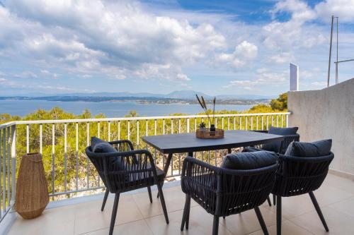 スペツェスにあるSUNSET220 spetsesのテーブルと椅子、水辺の景色を望むバルコニー