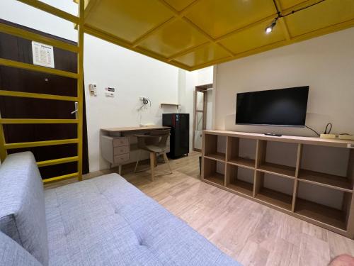 a bedroom with a bed and a tv and a desk at Choska Residence in Jakarta