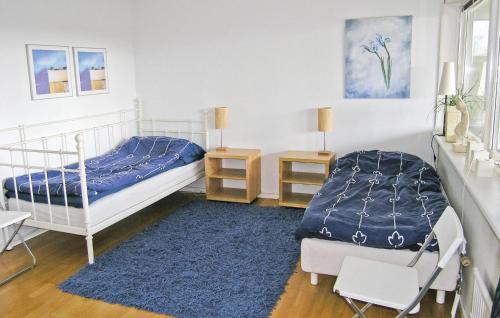 a bedroom with two beds and a blue rug at Stunning Home In Huskvarna With 3 Bedrooms And Wifi in Huskvarna