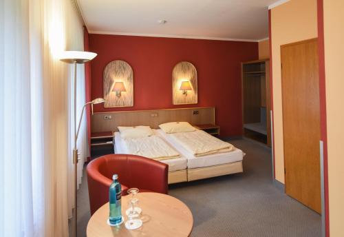 ein Hotelzimmer mit einem Bett und einem Tisch in der Unterkunft Seehof Netzen in Lehnin