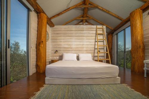 a bed in a room with windows and a ladder at Green Leaf in Vanáton