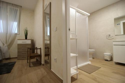 baño con espejo, mesa y silla en Apartamento turístico la Vera, en Aldeanueva de la Vera