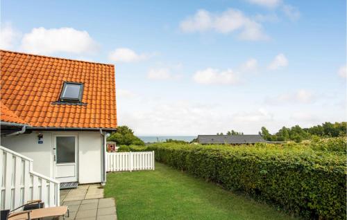a white house with an orange roof and a yard at 2 Bedroom Nice Apartment In Allinge in Allinge