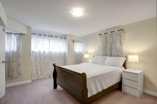 a bedroom with a large bed and a window at Beautiful 3-bedroom Suite on 1 Acre in Maple Ridge District Municipality