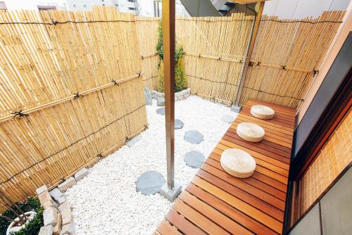 a backyard with a wooden bench and a fence at Skytree Tatami Hotel in Tokyo