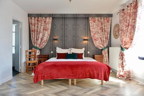 - une chambre avec un grand lit et une couverture rouge dans l'établissement La Domerie - Maison d'hôtes, à Aubrac