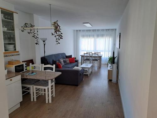 ein Wohnzimmer mit einem Sofa und einem Tisch in der Unterkunft Apartamento Calvarios in Sanxenxo