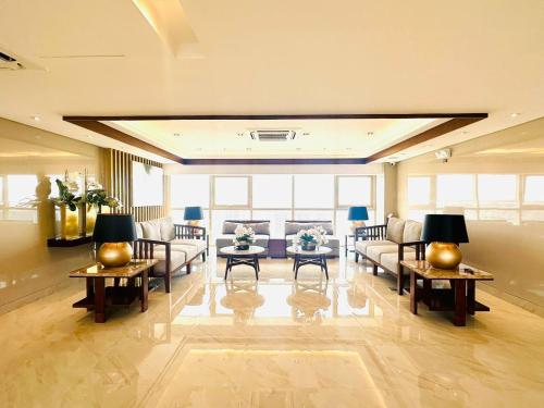 a large living room with couches and tables at Coast Residences - 2 Bedroom with Balcony facing Mall of Asia, Manila Bay & Pool View in Manila