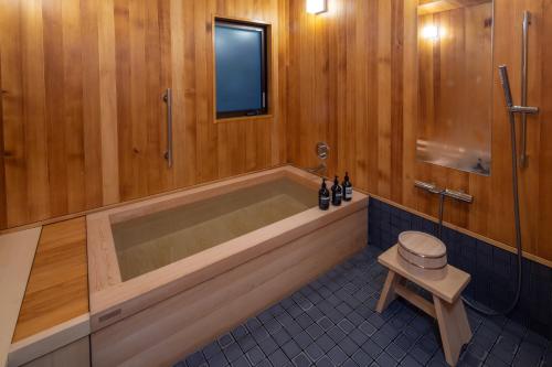 a large bathroom with a tub and a stool at Tsukihitei in Nara