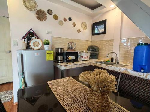 a kitchen with a refrigerator and a table with a pineapple at THE BALAY MOUNTAIN PEAK in Tanay
