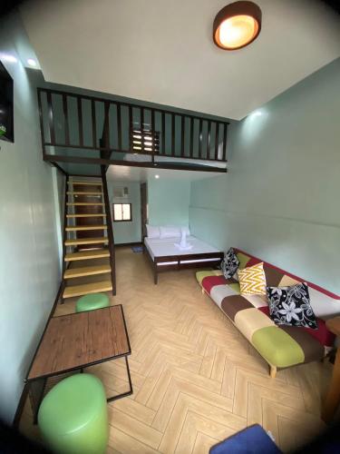 a living room with a couch and a staircase at Teteng's Apartelle in San Vicente