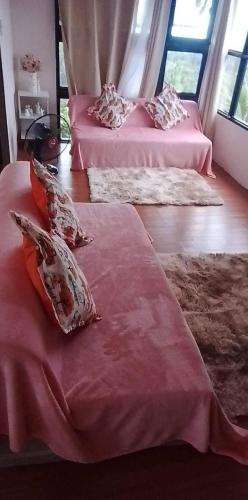 two beds in a room with pink sheets and pillows at THE BALAY MOUNTAIN PEAK in Tanay