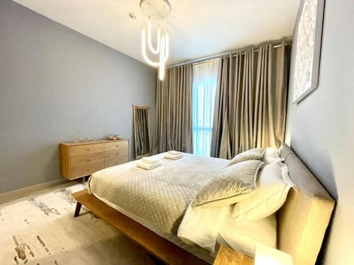 a bedroom with a large bed and a window at Dar Vacation - Modern Luxury 1BR Apartment in MJL in Dubai