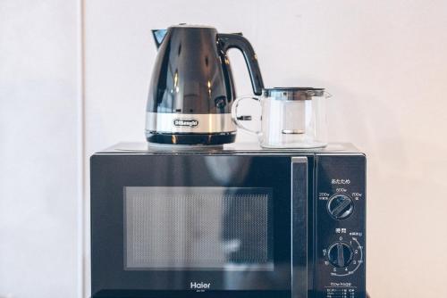a coffee pot sitting on top of a microwave at Nippori Fabric Hotel in Tokyo