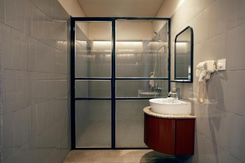 a bathroom with a sink and a glass shower at Liberta Hub Blok M Jakarta in Jakarta