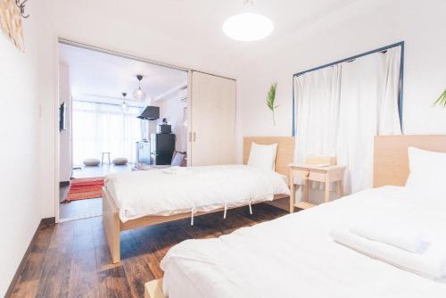 a bedroom with two beds and a window at Nippori Fabric Hotel in Tokyo