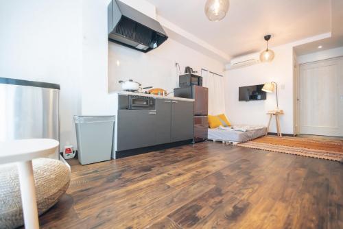 a living room with a kitchen and wooden floors at Nippori Fabric Hotel in Tokyo