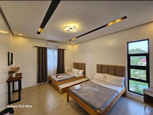 1 dormitorio con 2 camas y ventana en Obra Maestro Private Resort, en Lubao