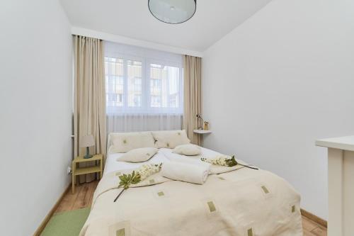 ein weißes Schlafzimmer mit einem Bett mit weißer Bettwäsche und Kissen in der Unterkunft Wrocław City Centre & Main Square Apartment by Renters in Breslau