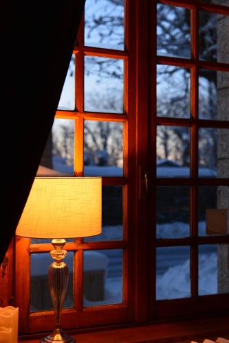 a lamp sitting in front of a window at La Domerie - Maison d'hôtes in Aubrac