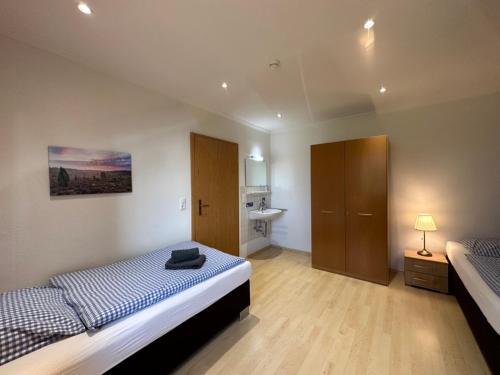 a bedroom with two beds and a sink in it at Heidhof in Bispingen