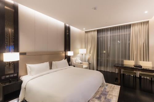 een slaapkamer met een groot wit bed en een bureau bij Bukit Bintang Signatures by Premium Hospitality in Kuala Lumpur