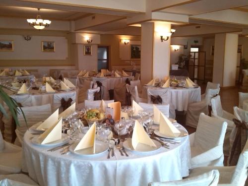 una sala per banchetti con tavoli bianchi e sedie bianche di Complex Europa L.G a Ploieşti