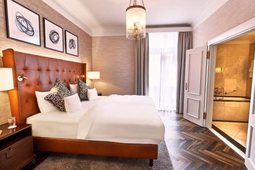 a hotel room with a large white bed and a window at Steigenberger Icon Parkhotel Düsseldorf in Düsseldorf