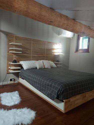 1 dormitorio con 1 cama grande y cabecero de madera en Loft Centro storico, en Sarnico