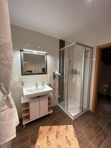 uma casa de banho com um lavatório e um chuveiro em Annalena´s Ferienhaus Hooksiel em Wangerland