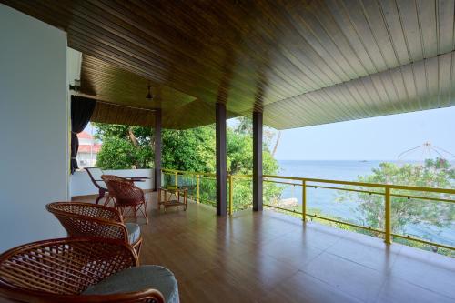 a room with chairs and a view of the ocean at Seclude by the Lake, Alleppey in Alleppey