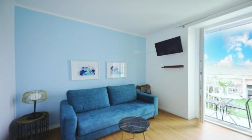 a blue couch in a living room with a window at Apartment Ajuda Tagus River View in Lisbon