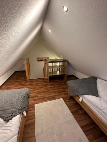 um quarto no sótão com 2 camas e uma mesa em Annalena´s Ferienhaus Hooksiel em Wangerland