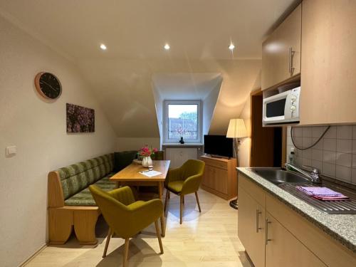 a kitchen and living room with a couch and a table at Heidhof in Bispingen