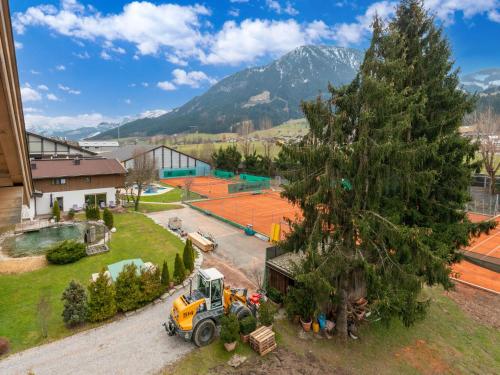 a large tree and a yellow truck next to a building at Luxury penthouse in Brixen im Thale with Parking in Brixen im Thale